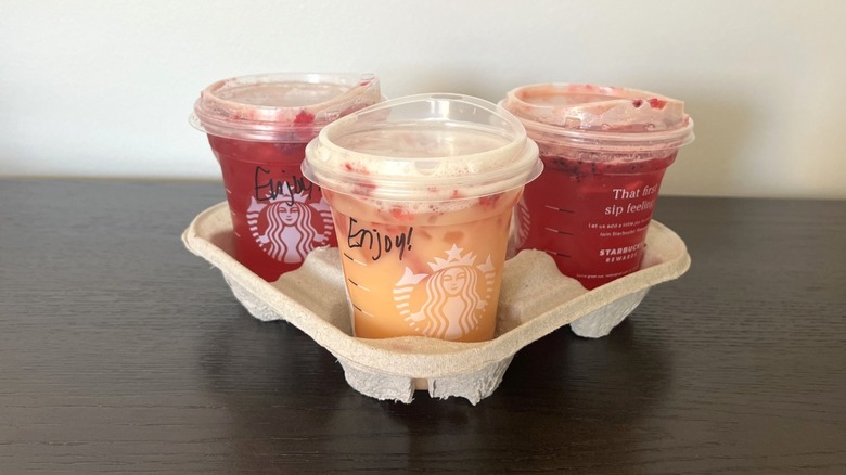 Three Starbucks Mango Strawberry Refreshers in drink carrier.