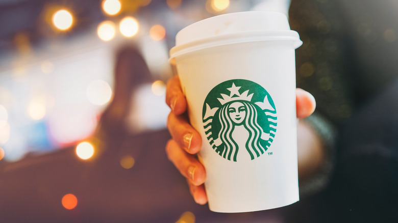 holding Starbucks cup, festive