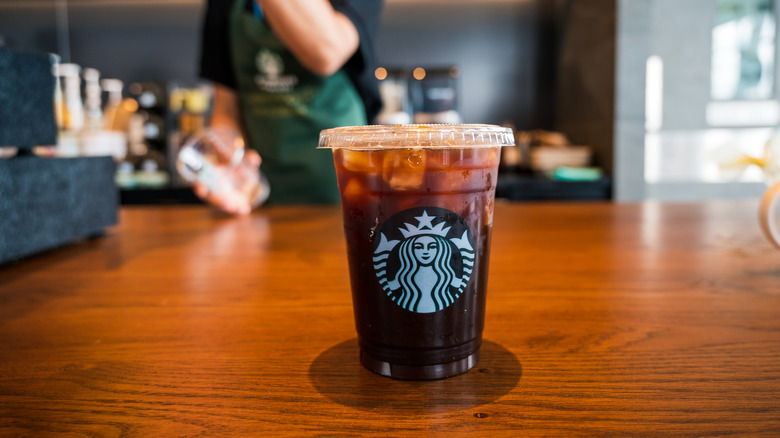 Starbucks cup employee in background