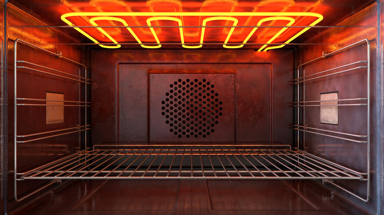 Electric heating element glowing red hot at the top of an oven