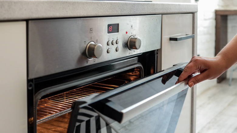 Hand opening an oven door