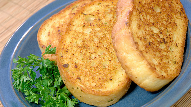 Three slices of Texas toast on a blue ceramic plate