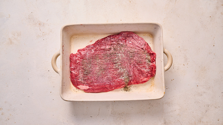 seasoning steak with salt and pepper