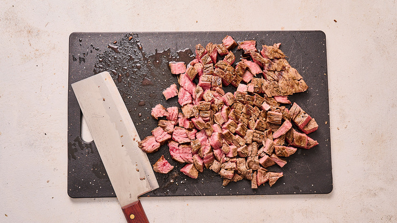 slicing steak on cutting board