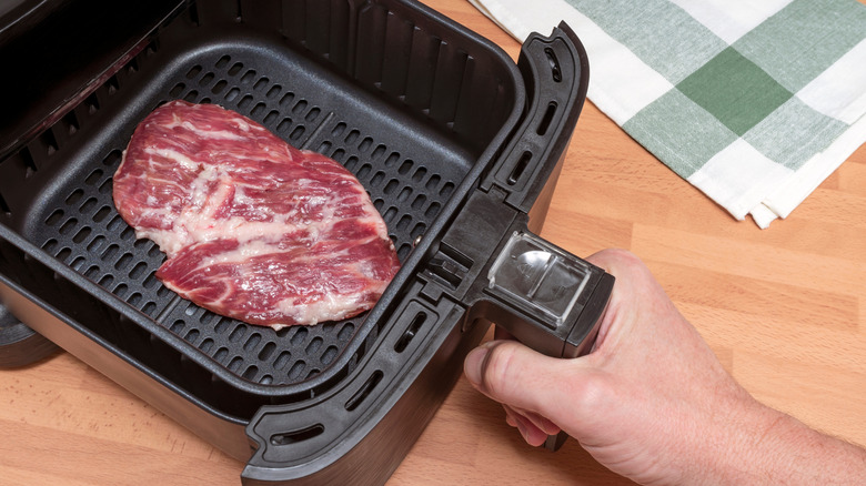 Steak being placed into air fryer