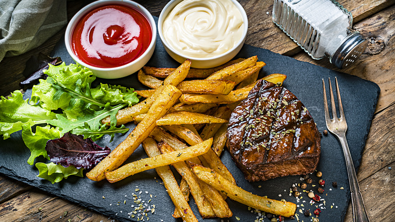 Well-done steak with fries, ketchup, and mayo