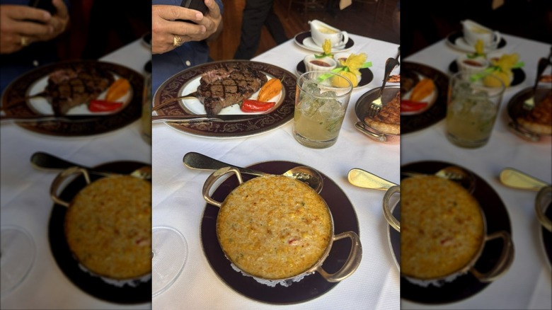 Bowl of lobster creamed corn served with steak on restaurant table