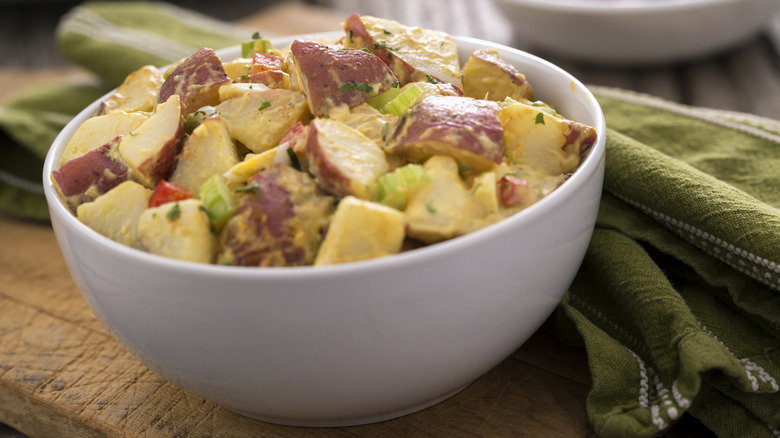 A white bowl of potato salad on a table