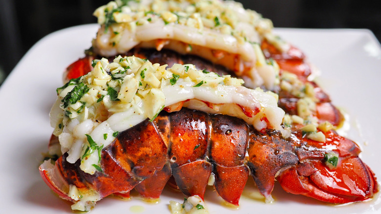 cooked lobster tails on a plate with toppings