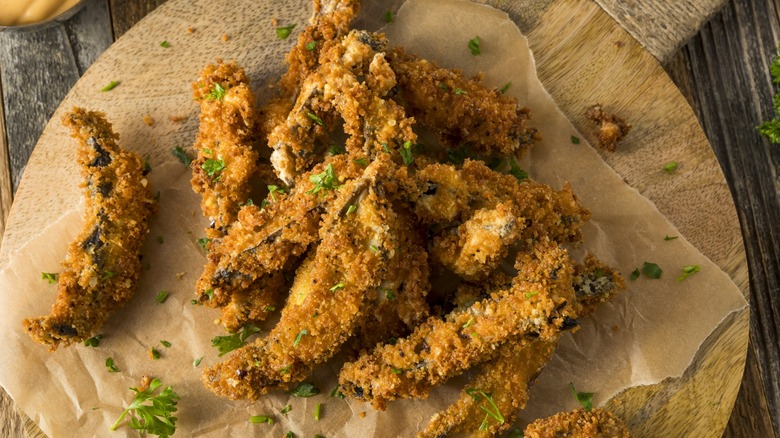 Top-down view of fried portobellos on a wooden tray