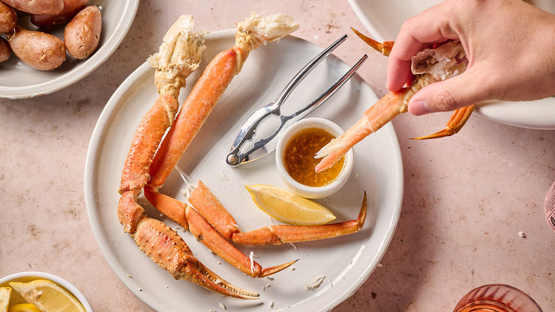 hand dipping crab into butter
