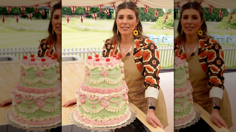 Bake Off contestant Georgie posing with her showstopper cake