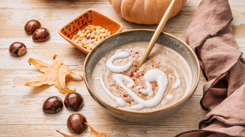 soup with cream swirl, nuts and seeds nearby