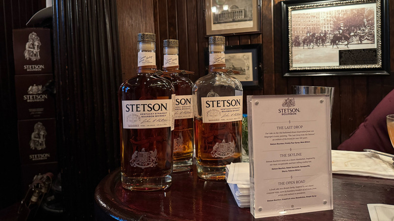 Bottles of Stetson Bourbon on bar, cocktail menu, historic pictures on wall