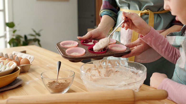 person and child making muffins