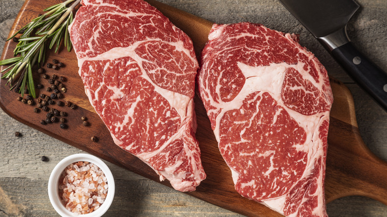 Two raw wagyu steaks on a cutting board