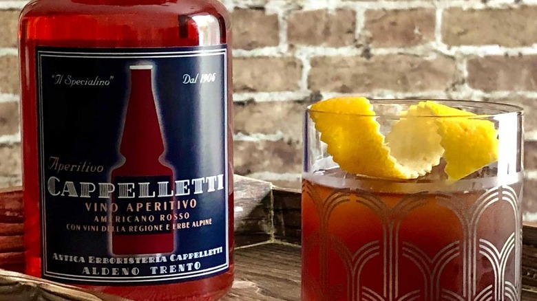 Close-up on Cappelletti bottle next to a cocktail on a bar