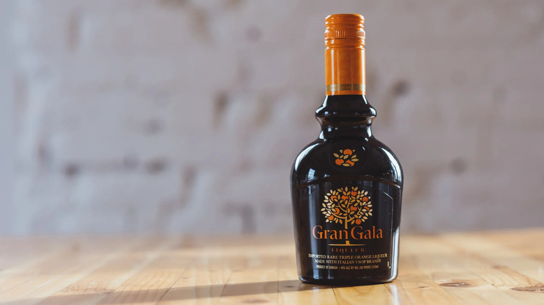 Bottles of Grand Gala on butcher block against white background.