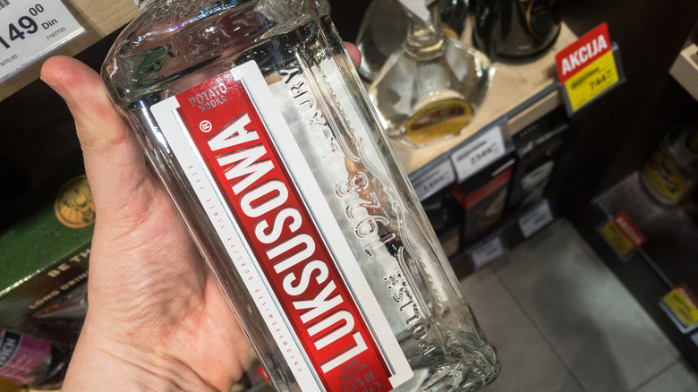 Person holding a bottle of Luksusowa vodka
