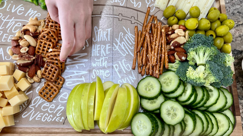 A hand arranging a veggie tray