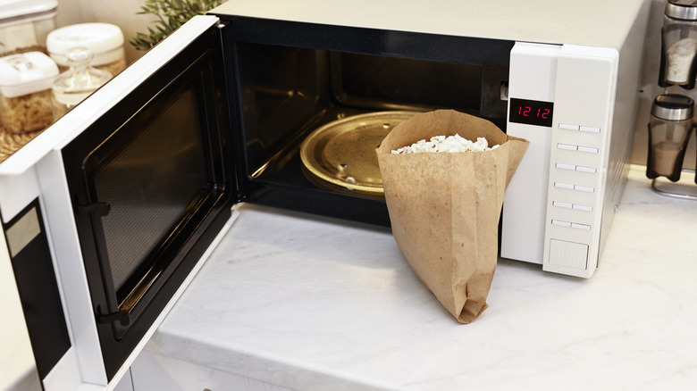 Popcorn in regular paper bag in front of microwave