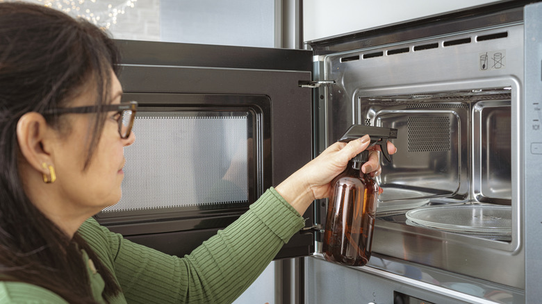 Woman cleaning inside of microwave