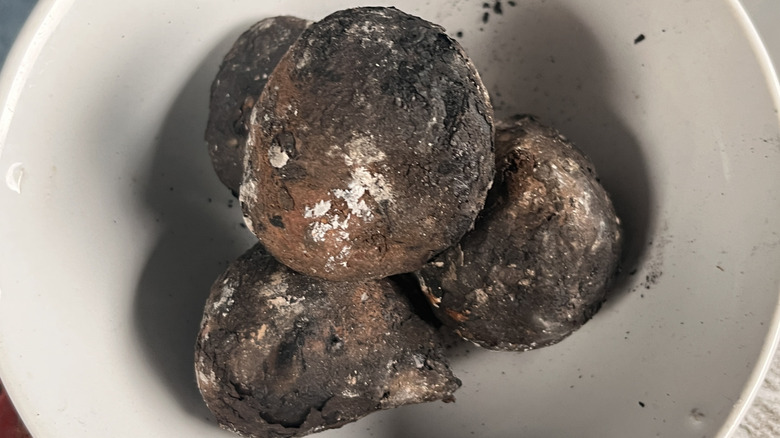 Plate of four burned potatoes