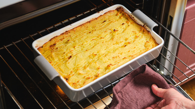 close up of a person removing a casserole from the oven