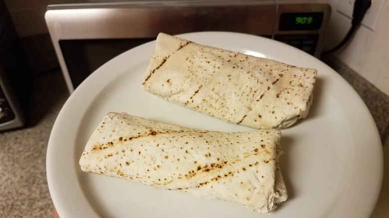 Frozen Burritos on a Plate in Front of the Microwave