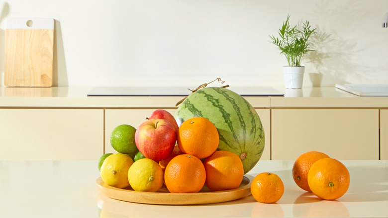 wood tray with citrus fruit on kitchen counter