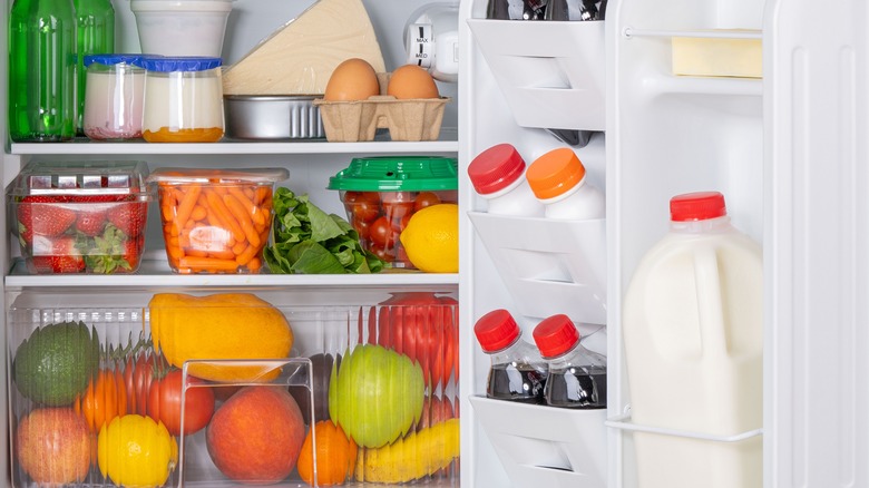 Open refrigerator with fruit on the shelves