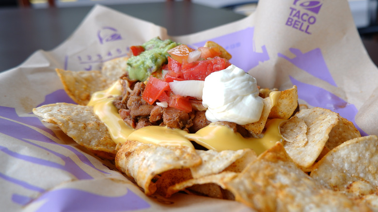 Taco Bell nachos in a basket lined with branded paper