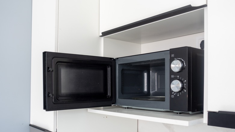 An opened microwave on the kitchen counter