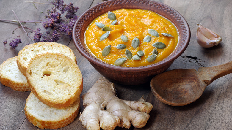 Bowl of soup with ginger root and sliced bread