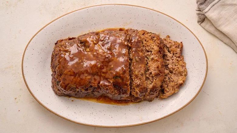Meatloaf with a coconut cream and gochujang glaze on a speckled white platter