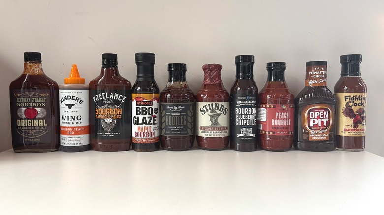 10 bottles of bourbon barbecue sauce lined up on white table