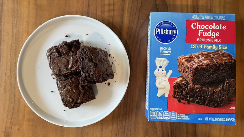 Pillsbury chocolate fudge brownie mix box and baked brownies on a plate