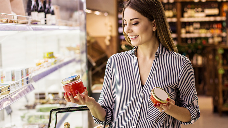 Woman comparing two items at a grocery store