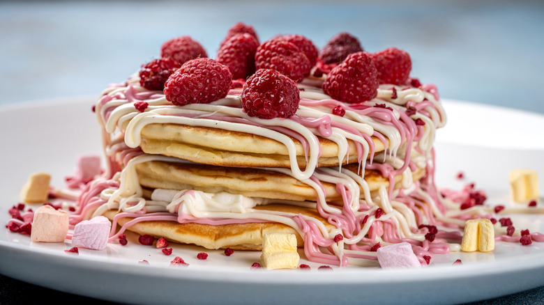 Pancakes with pink frosting and raspberries