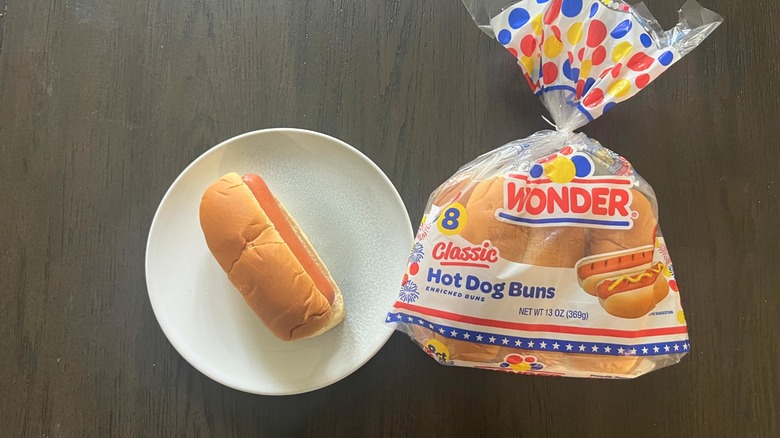 A bag of Wonder Classic Hot Dog Bun with one hot dog on a white plate