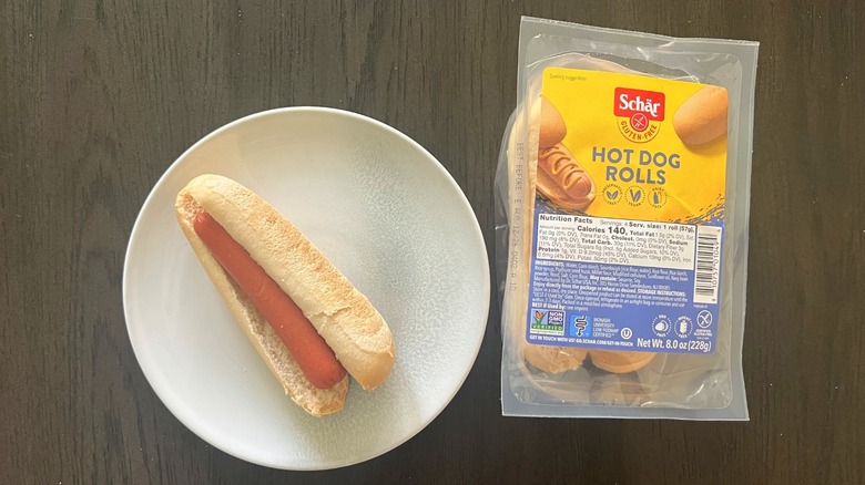 Schar Hot Dog rolls package with a hot dog on a plate