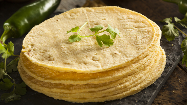 A stack of corn tortillas topped with cilantro