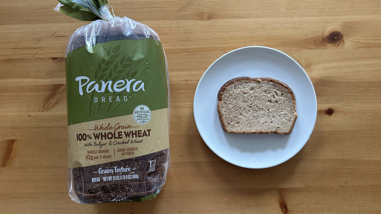 Panera Bread 100% Whole Wheat Bread package and slice on a white plate on a table