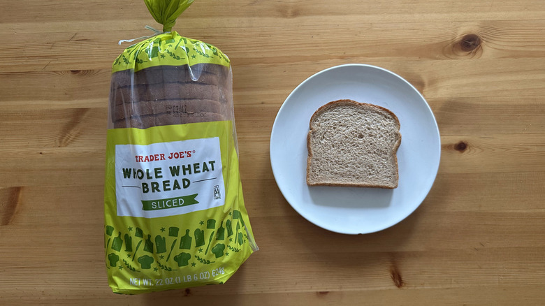 Trader Joe's Sliced Whole Wheat Bread package and slice on a white plate on a table
