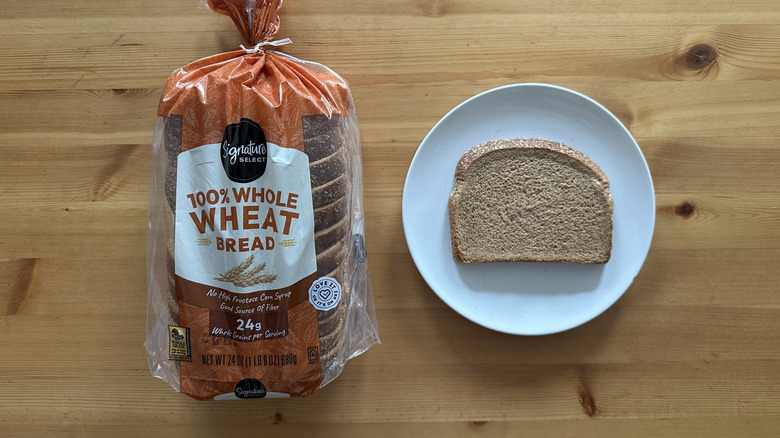 Signature Select 100% Whole Wheat Bread package and slice on a white plate on a table