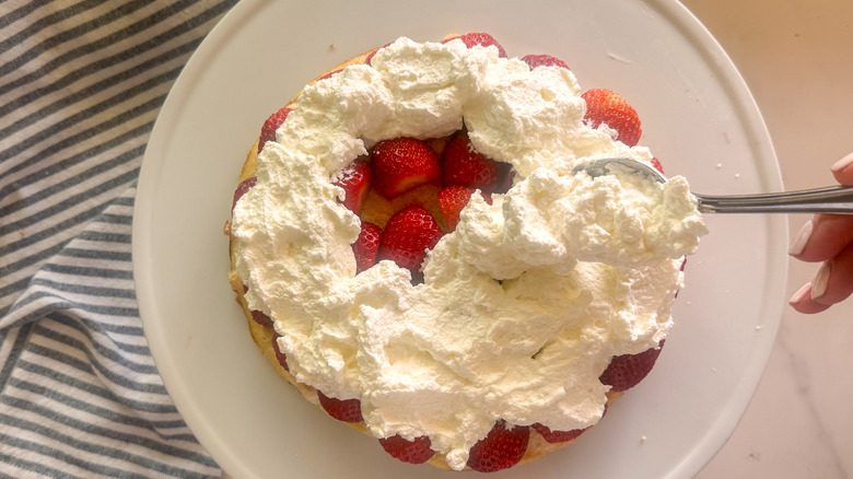hand spreading whipped cream