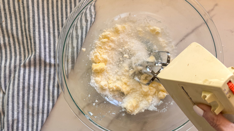 hand beating butter and sugar