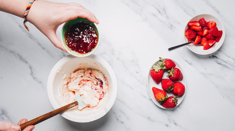 Adding jam to cheesecake filling.