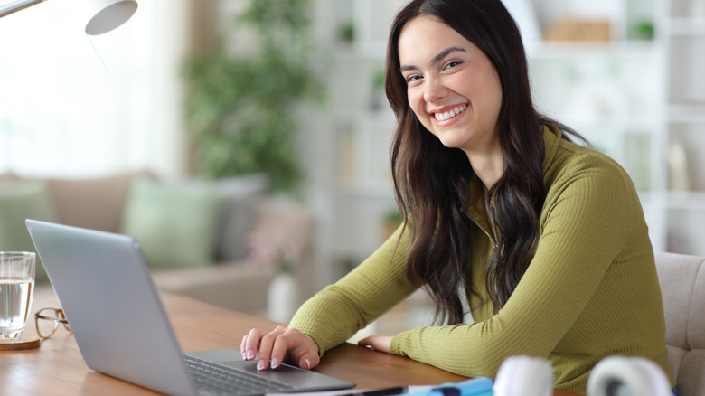 student at home using laptop looks at camera