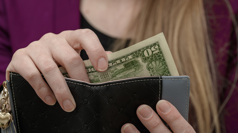 50 dollar usd bill being taken out of a wallet